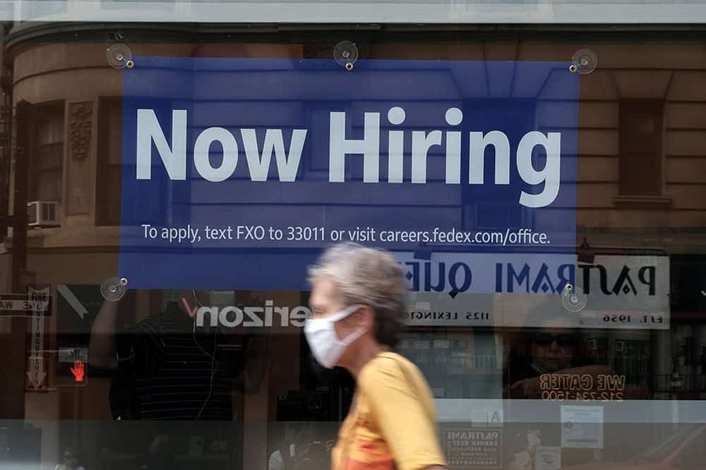 A hiring sign is displayed in a store window in Manhattan