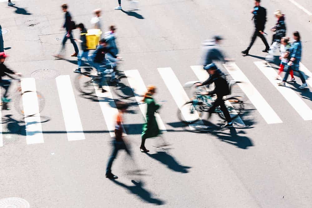 Blurred People And Cyclists Crossing Road