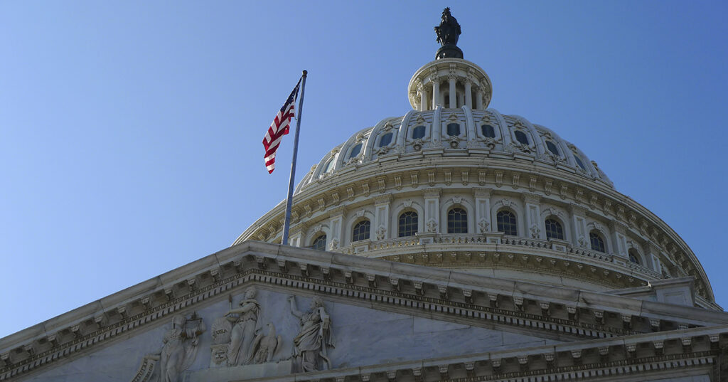 USA Capitol Building dome with American flag flying.