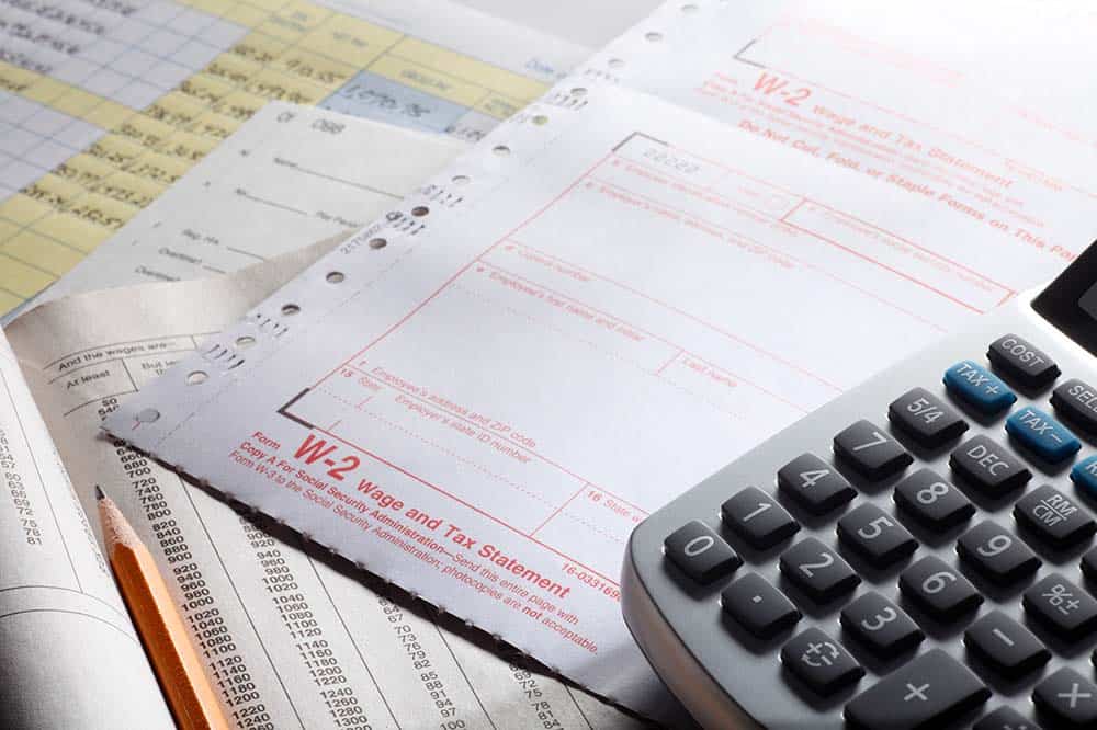 Image of payroll tax paperwork and a calculator.