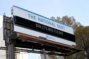 A poster and electronic billboard displayed near Ted Turner Dr and Marietta St that displays the current U.S. National debt per person and as a nation at 36 Trillion dollars