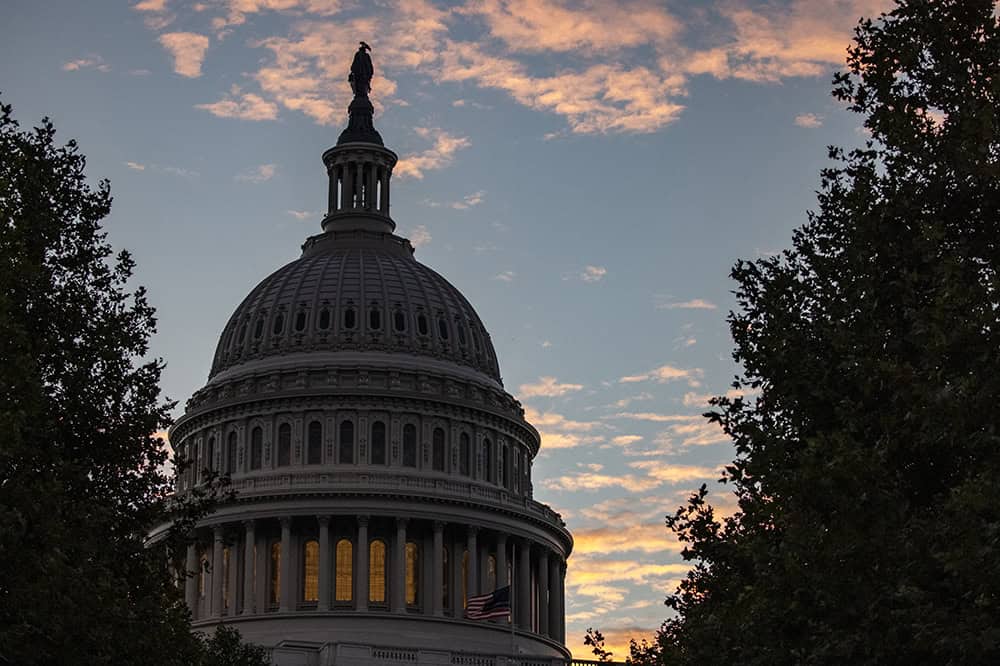 The sun rises behind the U.S. Capitol Building