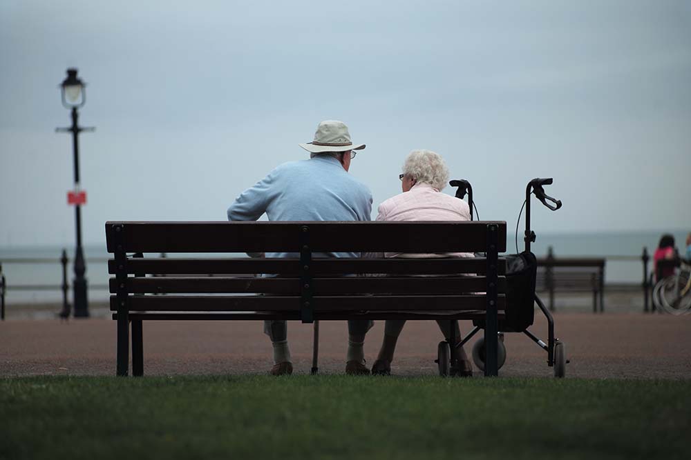 Elderly couple sitting on a bench.