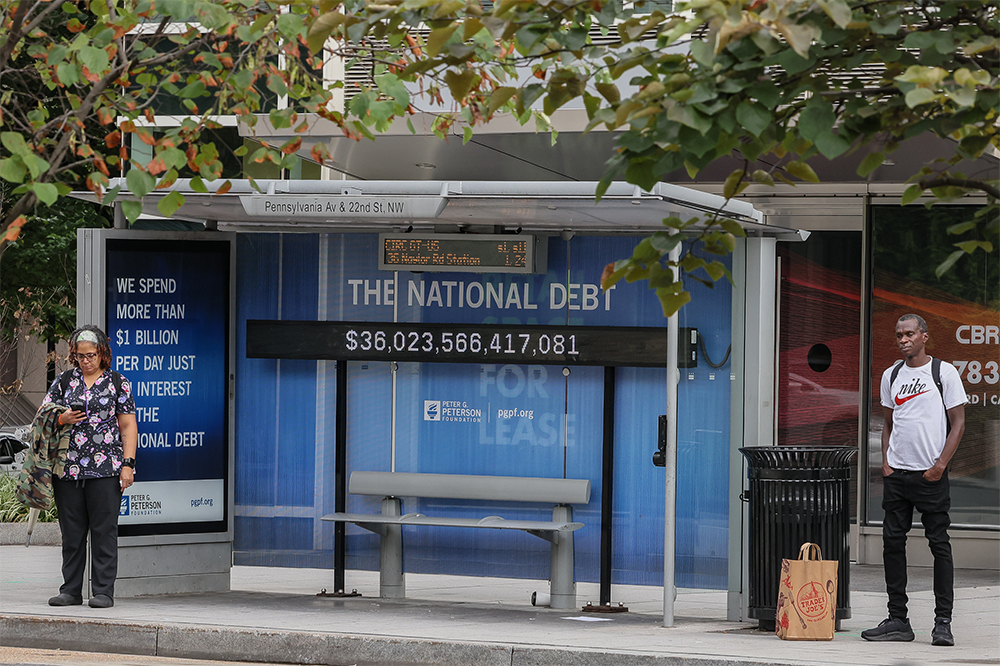 A view of a bus shelter at Pennsylvania Avenue and 22nd Street NW where an electronic billboard and a poster display the current U.S. National debt per person and as a nation at 35 Trillion dollars on August 08, 2024 in Washington, DC.