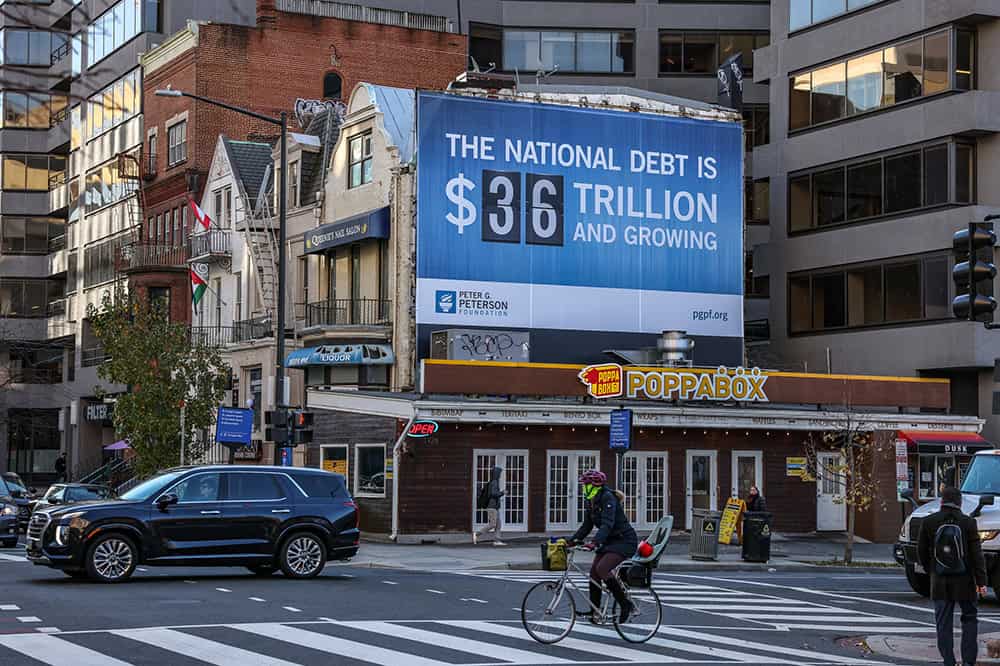 Wall billboard displaying The National Debt is now $36 Trillion