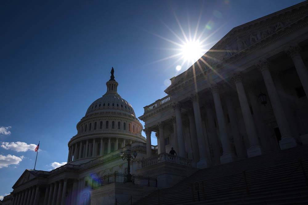 Image of the U.S. Capitol in shadow back lit by the sun