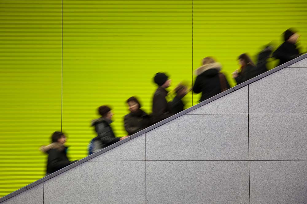 Shoppers going up an escalator.